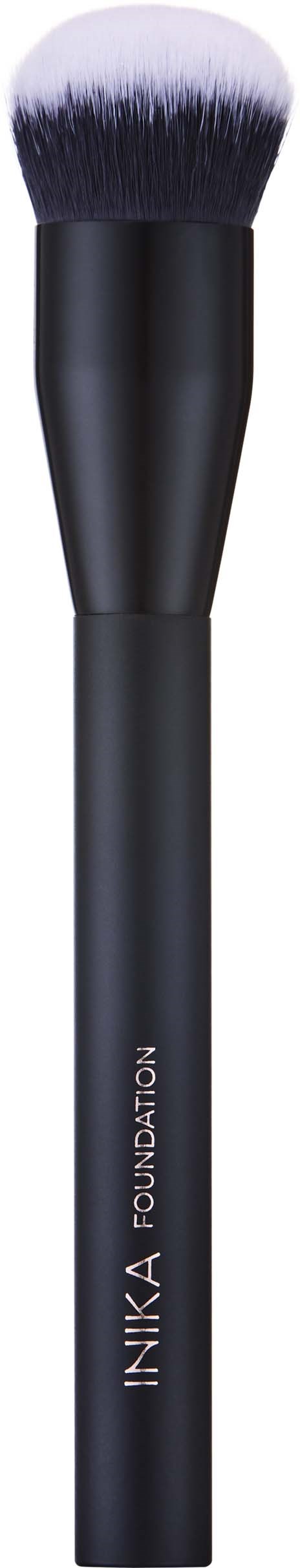 En svart makeupbørste med en rund, fyldig hvit tupp og et elegant håndtak merket "INIKA Foundation."