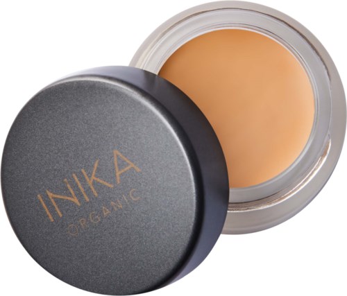 Ett litet runt glas med svart lock visar beige kräm inuti. Locket har märket 'INIKA ORGANIC'.