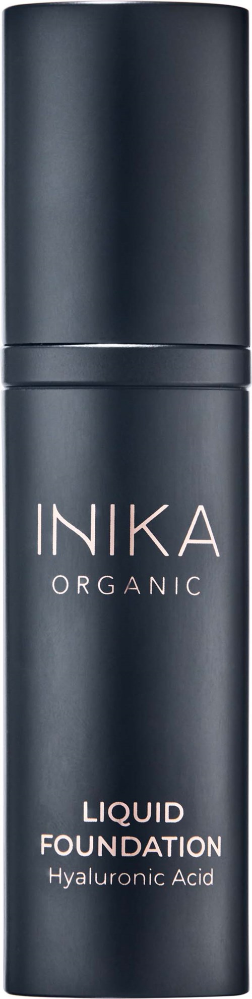 En svart flaske med pumpe, merket 'INKA ORGANIC LIQUID FOUNDATION Hyaluronic Acid', står mot en svart bakgrunn.