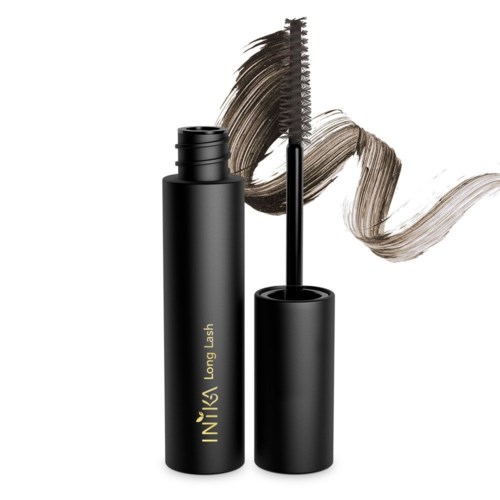En svart mascara-rör med tappad borste, visar mörk mascara och en brunaktig fläck bakom.