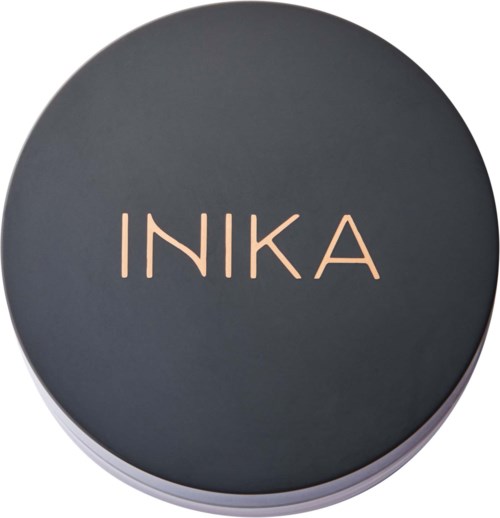 A round black container with the word INIKA written on the lid in light pink letters.