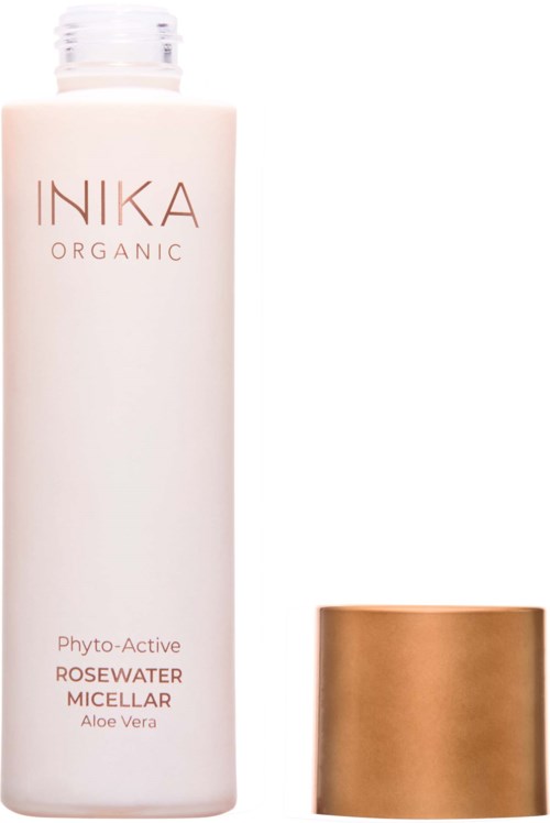 En hvid flaske med INIKA Organic Rosewater Micellar med en gylden hætte ved siden af.