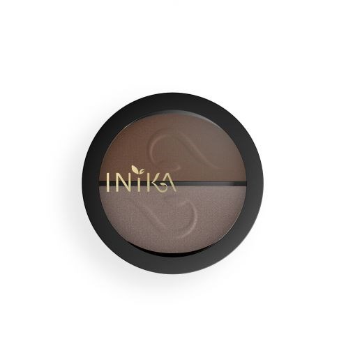 En rund makeup-palett med bruna och grå nyanser, märkt med en svart och guld logotyp, på vit bakgrund.