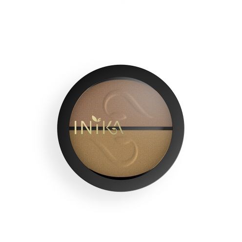 En rund kosmetisk dosa med svart kant innehåller två nyanser av beige smink, med varumärket 'INKA' på.
