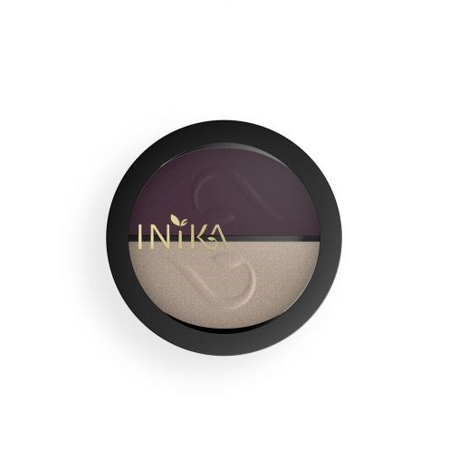 En rund makeup-rourr med mörklila och ljusbeige pulver inuti, och varumärket INIKA på.