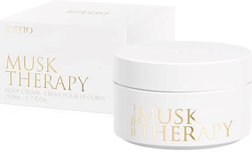 Biały słoik kremu do ciała Musk Therapy z złotym napisem i pasujące białe opakowanie.