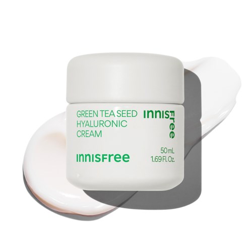 Ein weißer Behälter mit grüner Schrift sagt 'Innisfree Green Tea Seed Hyaluronic Cream' mit Creme daneben.