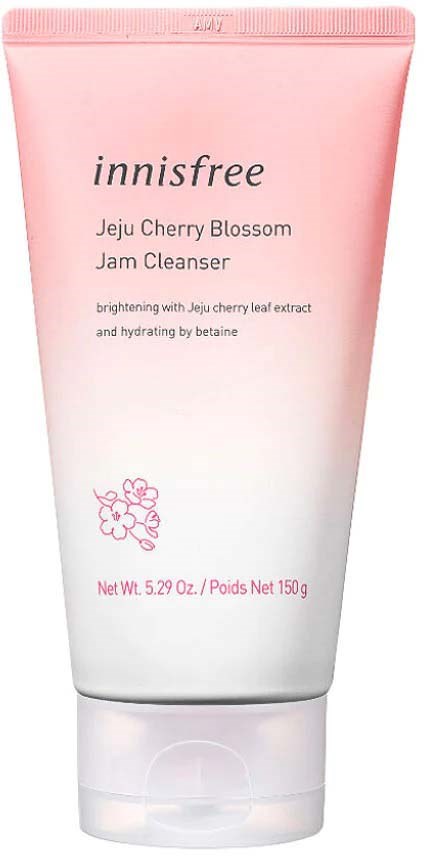 En rosa och vit tub märkt 'Innisfree Jeju Cherry Blossom Jam Cleanser' med körsbärsblommor.