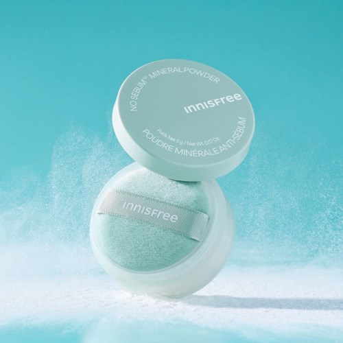 A round container of Innisfree mineral powder with a light blue lid, one half open showing the powder inside.