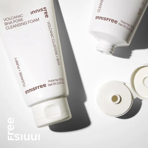 To hvide rør af Innisfree hudplejeprodukter, et med låget af, på en hvid overflade med skygger.