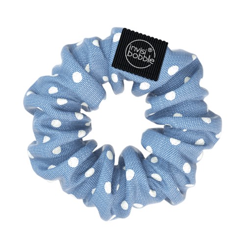 Ett blått hårband av tyg med vita polkagrisar och en svart loggpatch som säger 'Invisibobble'.