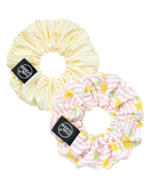 Two soft, striped fabric hair scrunchies, one yellow and white, the other pink and yellow, with black labels.