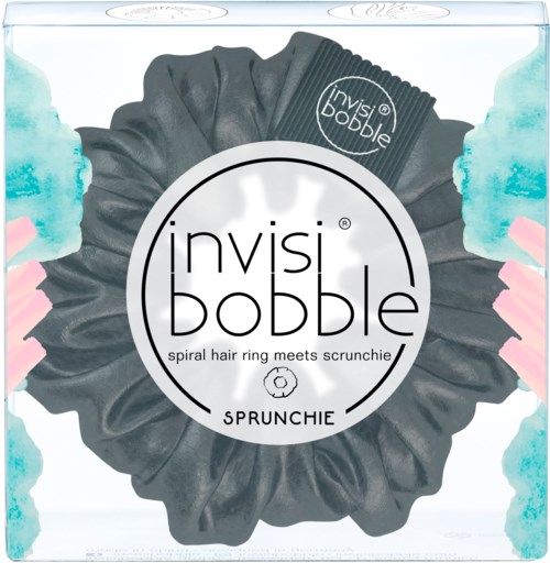 Ett tydligt box innehåller en svart spiralhårsnodd som heter Invisibobble, med märkeslappar för scrunchies inuti.