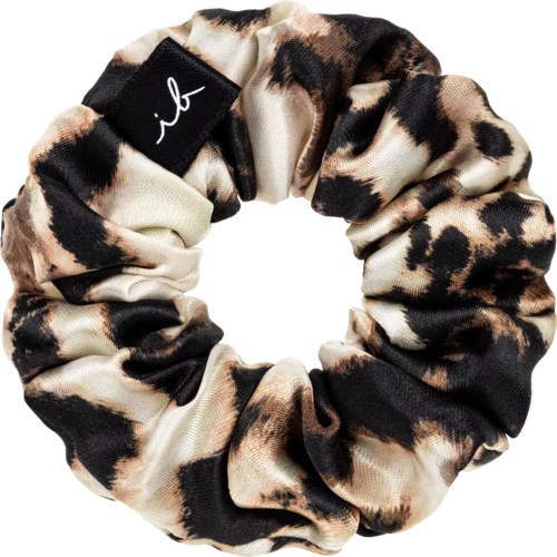 A leopard-print fabric scrunchie with a black tag, shaped in a circle.