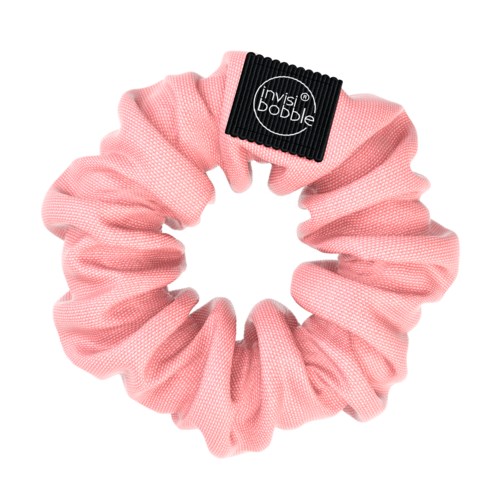 Ett rosa tyg-hårsnöre med en svart etikett som säger 'invisibobble'.