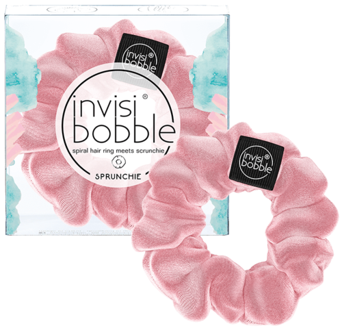 En rosa spiralhårsnodd kallad Invisi Bobble, med ett scrunchie-liknande utseende, i genomskinlig förpackning. Två svartmärkningar säger 'Invisi Bobble.'