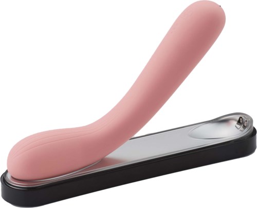 Et rosa, buet objekt på en svart base, ser ut som et leketøy eller voksenartikkel, med en blank metalldel.