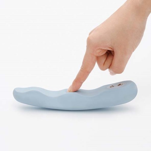 A person presses a finger on a soft blue object that looks like a floating, curved cushion.