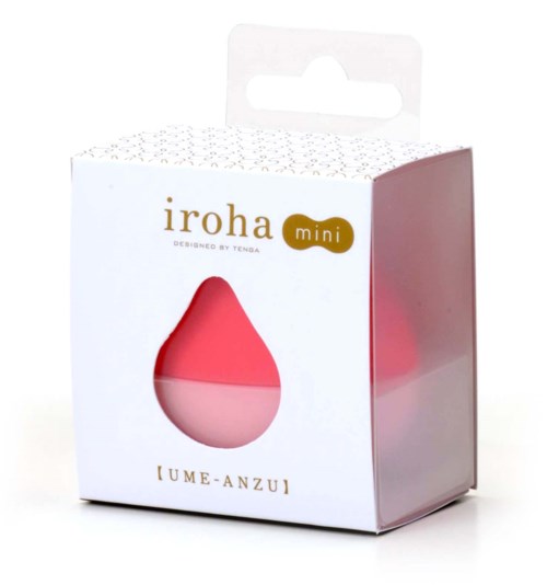 En liten, rosa, tåreformet gjenstand i en hvit boks med klar vindu og gull- og brunt tekst.