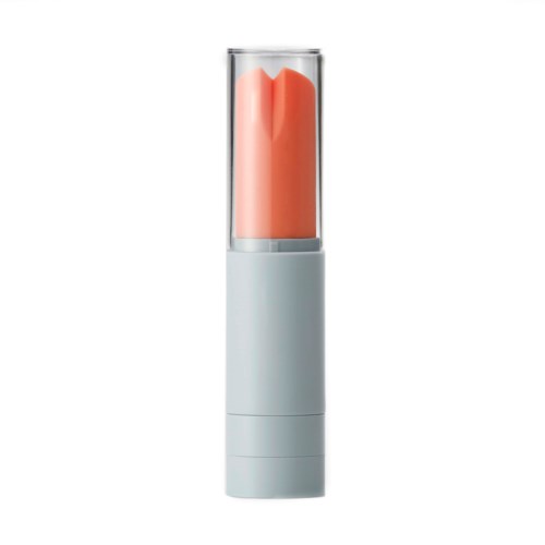 En liten enhet med hvit base og gjennomsiktig topp som viser en rosa-oransje form inni.