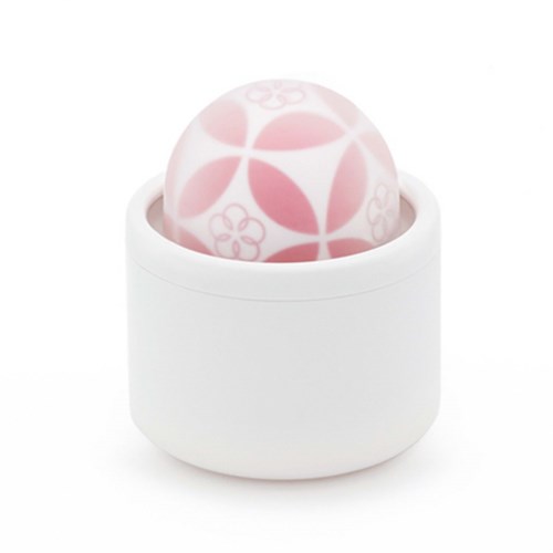 En hvit beholder med en mønstret rosa og hvit ball inni.