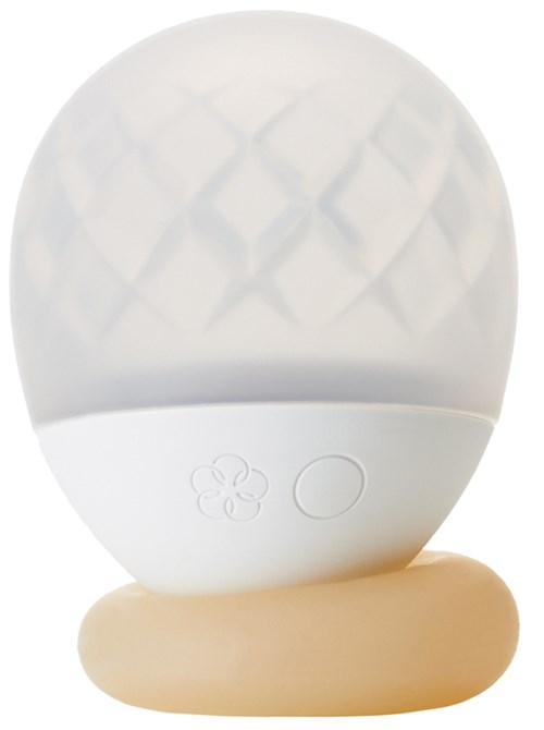 Et hvitt eggformet objekt med en teksturert topp, en knapp og et blomstersymbol, som står på en beige base.