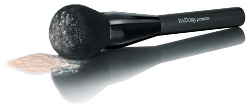 A makeup brush with black handle, powder spilled on brush and surface, and text 'IsaDORA powder' on handle.