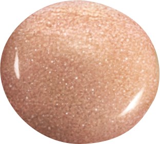 En närbild av en beige, glitterig, rund kosmetikprodukt, möjligen en foundation eller makeup.
