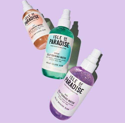 Three bottles of self-tanning water in pink, green, and purple, labeled 'Isle of Paradise,' on a purple background.