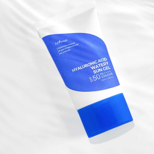 En hvid tube med blå label, nævner hyaluronsyre vand solgel, SPF 50+, UVB og UVA beskyttelse.