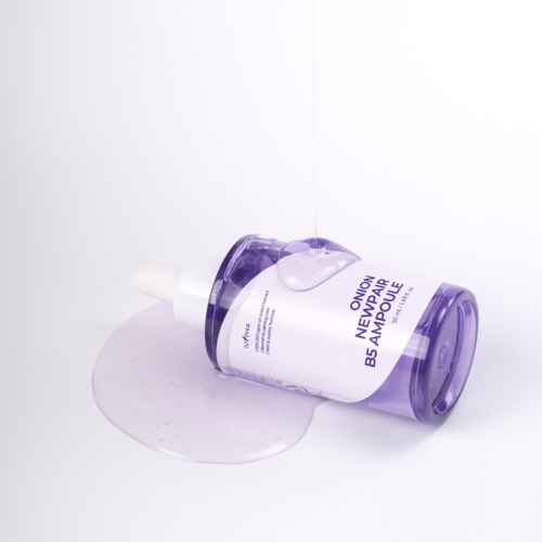 A white and purple bottle labeled 'Onion Newpalm BS Ampoule' with spilled liquid around it.