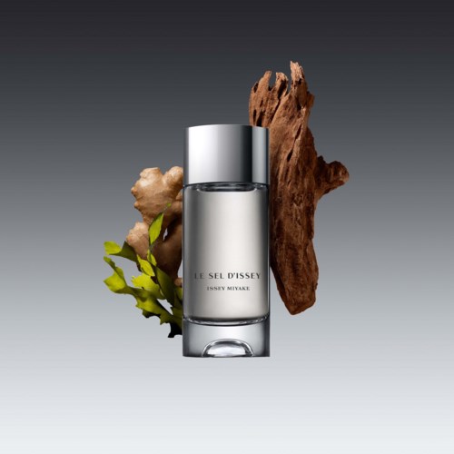 En parfymflaska märkt "Le Sel d'Issey" med naturliga ingredienser bakom.
