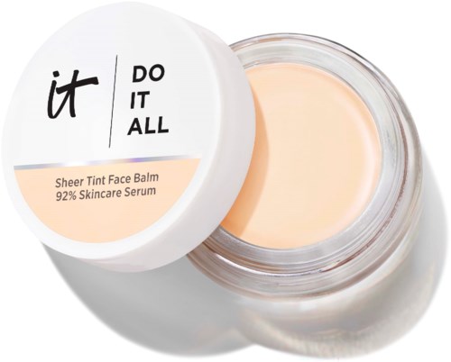 En krukke med Sheer Tint Face Balm med hvit lokk med svart og ferskengrønn tekst, viser balsamen inni.