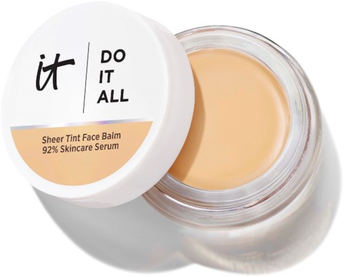 Et glass med Sheer Tint Face Balm med delvis åpen lokk som viser den lyse beige kremen inni.