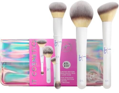 Four large and two small makeup brushes with a shiny, colorful case in the background.