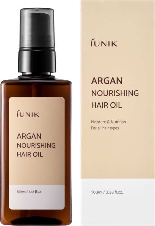 En brun flaska med hårolja med pump, bredvid en beige förpackning med produktinformation.
