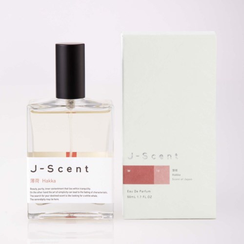 Eine klare Parfümflasche mit schwarzem Deckel neben einem weißen Karton mit J-scent W Hakka, 50ml.