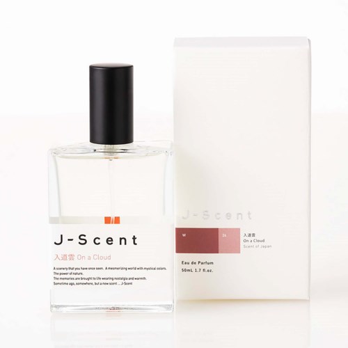 Eine klare Parfümflasche mit schwarzem Deckel und eine weiße Schachtel daneben, beide mit J-Scent beschriftet, auf weißem Hintergrund.