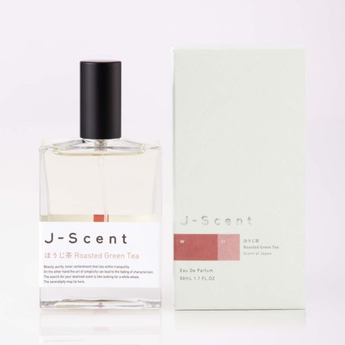 Ein klarer Glaspumpspender mit schwarzem Deckel neben einer weißen Verpackung mit J-scent und geröstetem grünen Tee Duft.