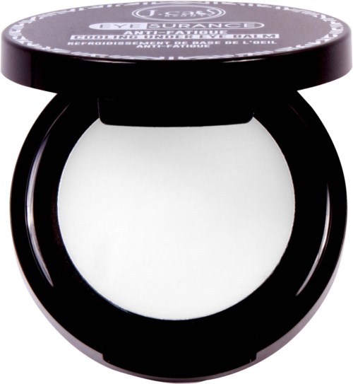 En svart rund beholder med lokk, inneholder hvit makeup, merket 'Urban Decay, Scrumptious Dose, Rehydrating Eye' under lokket.