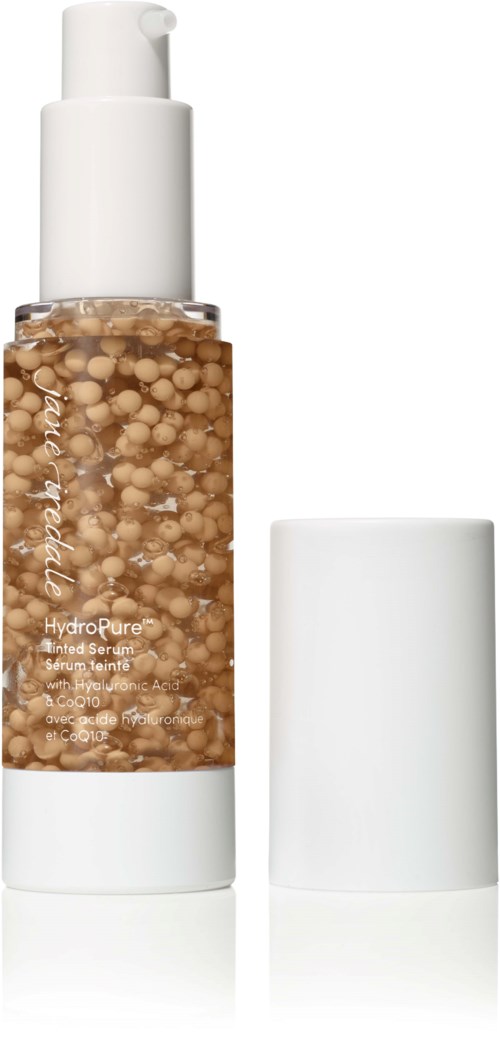 A clear pump bottle with tan-colored capsules, and a white cap beside it.