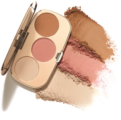 Makeuppalett med tre pulver: beige, rosa och ljusgrå. Pulver spilldes på ett vitt underlag.