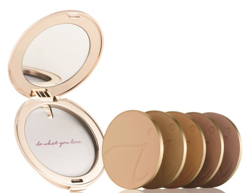 A compact mirror with a lid that has a colorful phrase inside; five pressed powder face shades in shades of pink and brown.