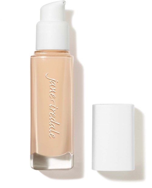 A beige liquid foundation bottle with a white pump and a white cap beside it.
