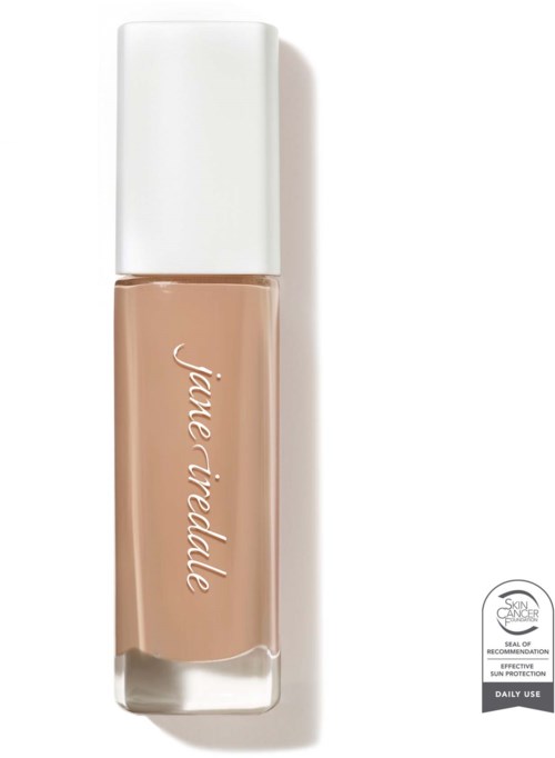 A beige liquid foundation in a clear bottle with a white cap and handwritten-style label. SPF and daily use labels are visible.