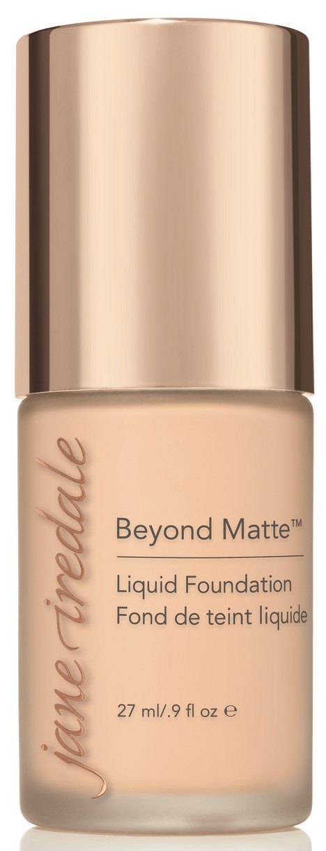 En flaska av Jane Iredale Beyond Matte flytande foundation med guldlock visas mot en svart bakgrund.
