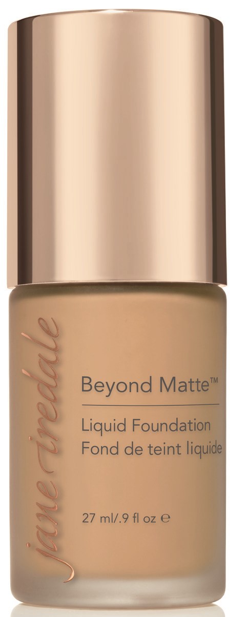 En beige flytande foundation i en glasflaska med guldkapsel och rosa textetikett.