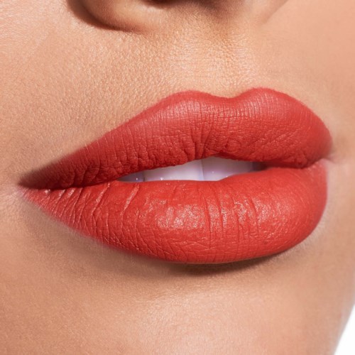 Close-up van lippen met rode lipstick, licht geopend met tanden zichtbaar. De huid errond is glad en licht.