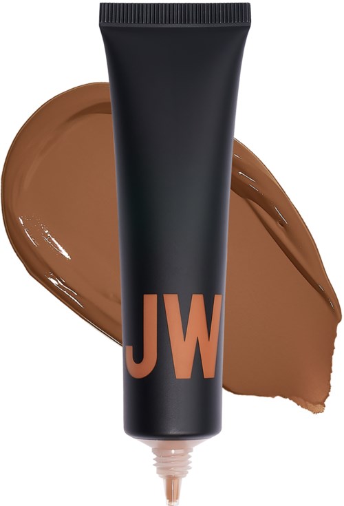 En svart tube med 'JW'-logo, spredd av brun krem eller lotion bak den.