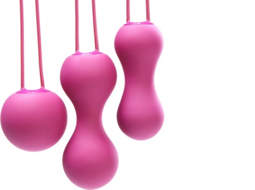 Roze voorwerpen hangen met koorden, sommige zijn rond en andere zijn uurglasvormig.